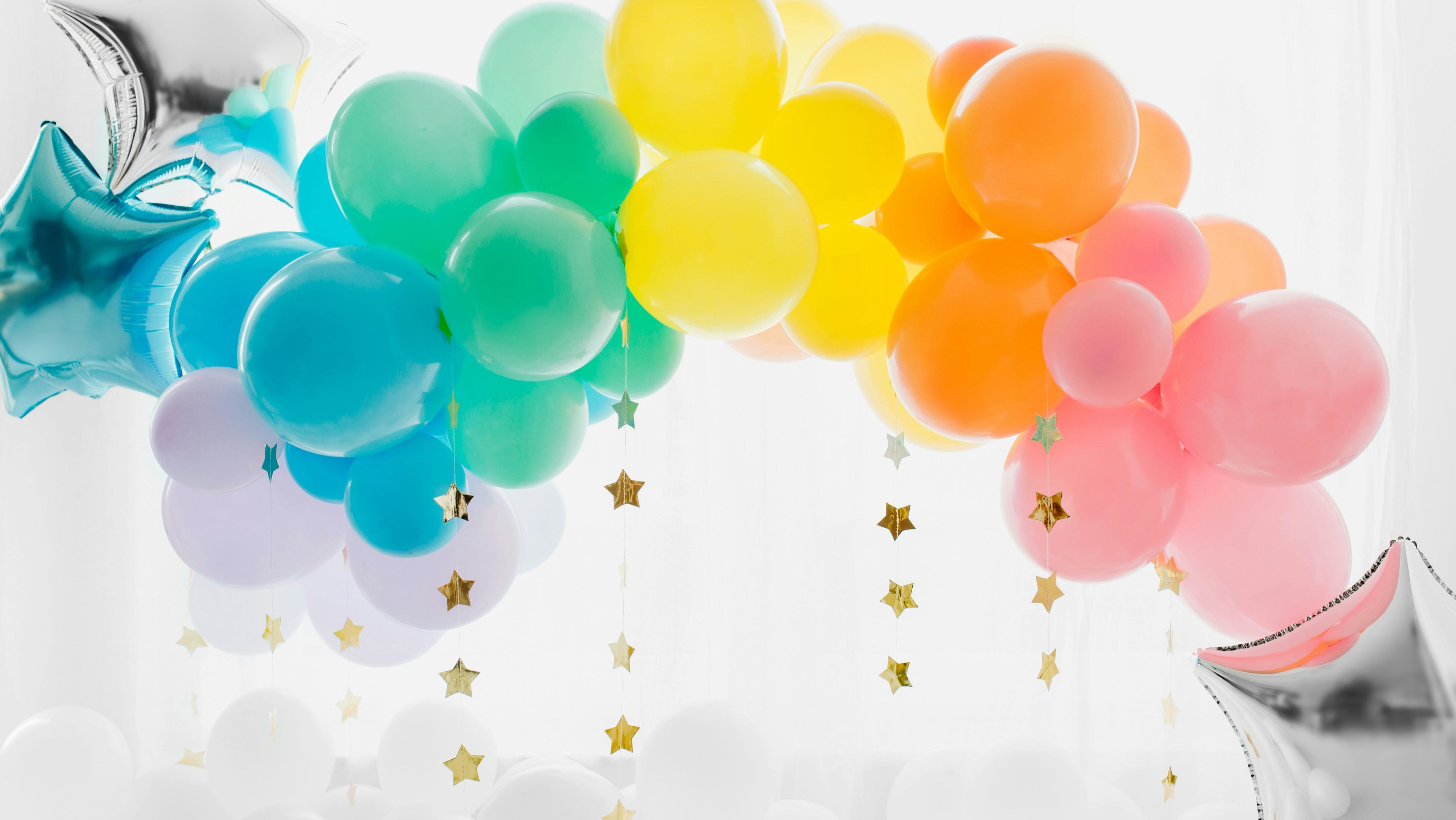 Colorful balloon arch with star-shaped balloons on a white background